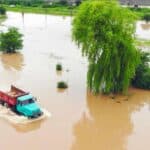 Truck driving through flooded area after heavy rainfall.